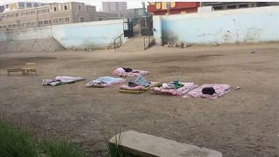 مراقبو الثانوية العامة في فناء إحدى المدارس 