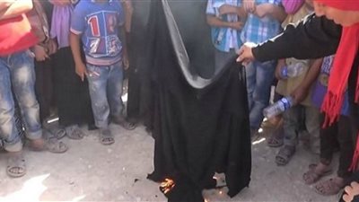 مواطنة سوريّة تحرق نقابها احتفالًا بطرد 