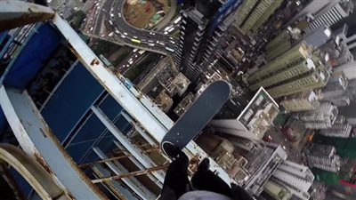 مغامر يتزلج على حافة ناطحة سحاب شاهقة