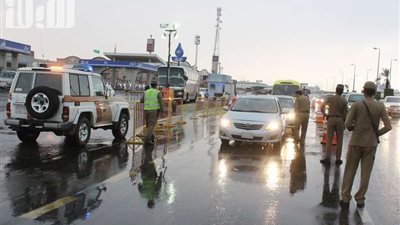 رجال الأمن بالطائف يقفون تحت المطر لضبط مخالفي الحج وناقليهم