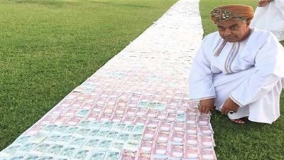 عروس عمانية تسير على ممر من عملات ورقية بـ 10 ملايين ريال (صورة)