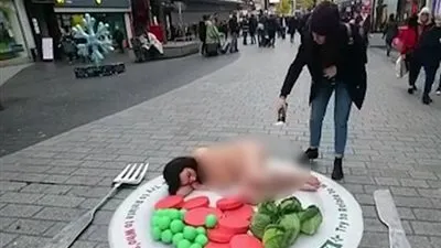 فتاة تنام عارية في وسط الطريق.. فهذا هو مطلبها! (فيديو)