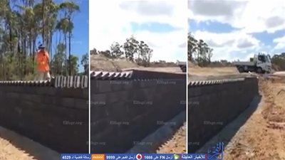 عمال ينهون بناء جدار بطريقة أحجار الدومينو