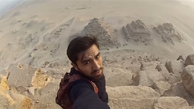 في مشهد مروع.. شاب يتسلق ويلتقط سلفي من اعلى قمة هرم خوفو ! (فيديو)