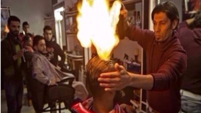 بهذه الطريقة حلاق يجفف شعر أحد زبائنه بالنار !
