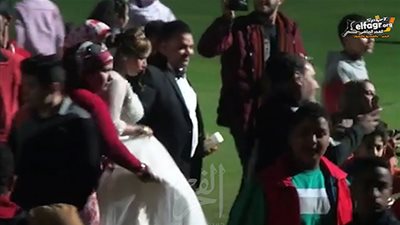 عريسان يتابعان مباراة المنتخب وسط الجمهور في المركز الأوليمبي بالمعادي (فيديو)