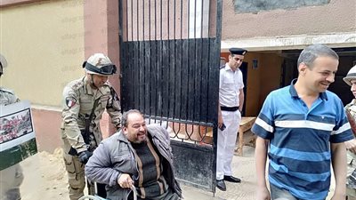 ضابط جيش يحمل معاق للإدلاء بصوته في الاستفتاء على الدستور بطوخ (صور)