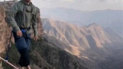 مشاهد تحبس الأنفاس لمغامر يسير على حبل بين جبال بالسعودية