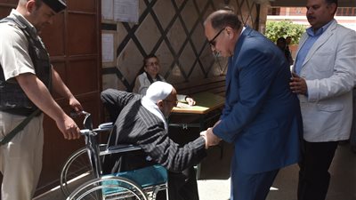محافظ الفيوم يصطحب مسن معاق ليدلي بصوته فى لجنة الاستفتاء على التعديلات الدستورية (صور)