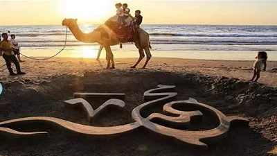 رسالة محبة في مظروف رملي.. رسام فلسطيني ينحت اسم 