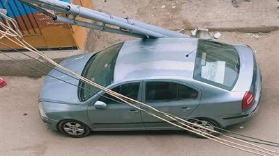 سقوط عمود كهرباء على سيارة بجوار مدرسة في دمنهور (صور)