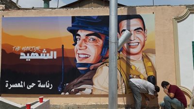 حي المعصرة يزين جدرانه بصور الشهيد 