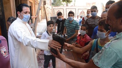 مسيحي في العمرانية يشارك المسلمين فرحتهم بتوزيع الهدايا على الأطفال (صور)