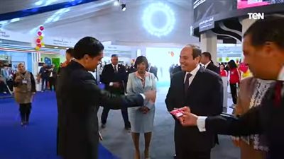 أحد ذوي الهمم يهادي السيسي خلال معرض 