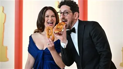 كيتي لويس وآدم شابيرو يكسران بروتوكول الأوسكار بتناول الكعك في افتتاح السجادة البيضاء