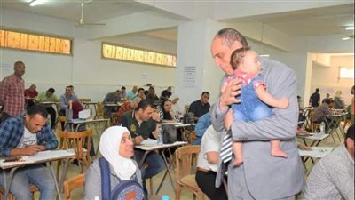 عميد تجارة طنطا يحمل طفلة إحدى طالبات الدراسات العليا أثناء أدائها الامتحان