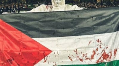 << تضامنًا مع غزة >> مشجعون ريال سيوسيداد الإسباني يرتدون ملابس بيضاء ملطخة بالدماء ويحملون أعلام فلسطين أثناء مباراة بنفيكا 