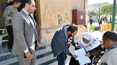 رئيس لجنة منشية التحرير بعين شمس يتوجه خارج اللجنه للحصول على تصويت سيدة قعيدة