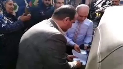 رئيس لجنة يساعد سيدة من ذوي الاحتياجات الخاصة للتصويت في القليوبية