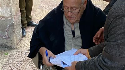 رئيس لجنة يساعد مسنا للإدلاء بصوته في لجنة زاوية بلتان بطوخ