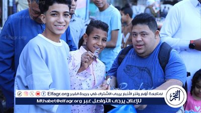 شاب قبطي من ذوى الهمم يوزع حلوى العيد بالأقصر